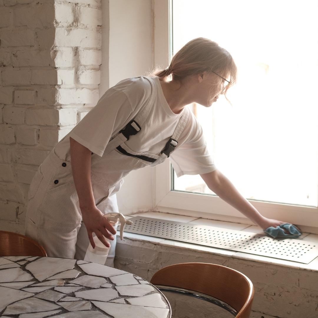 Woman cleaning windowsill