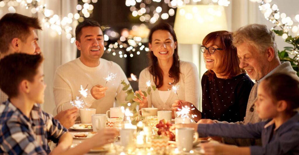 Family holding sparklers around table