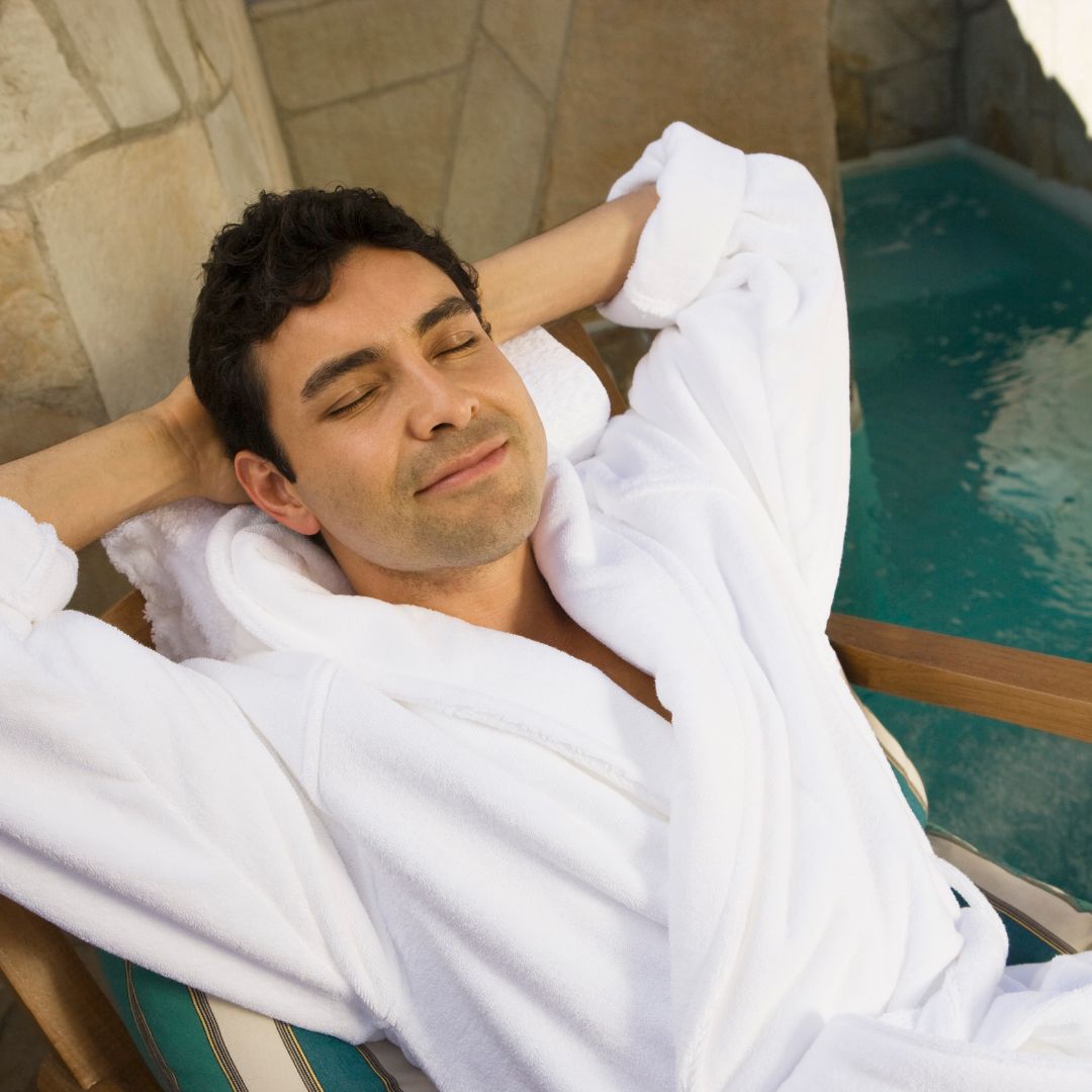 Man in white robe relaxing by pool