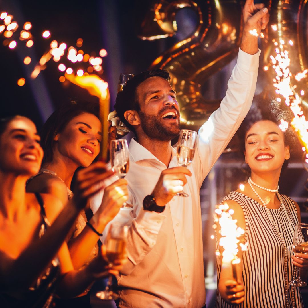 Four people party with sparklers