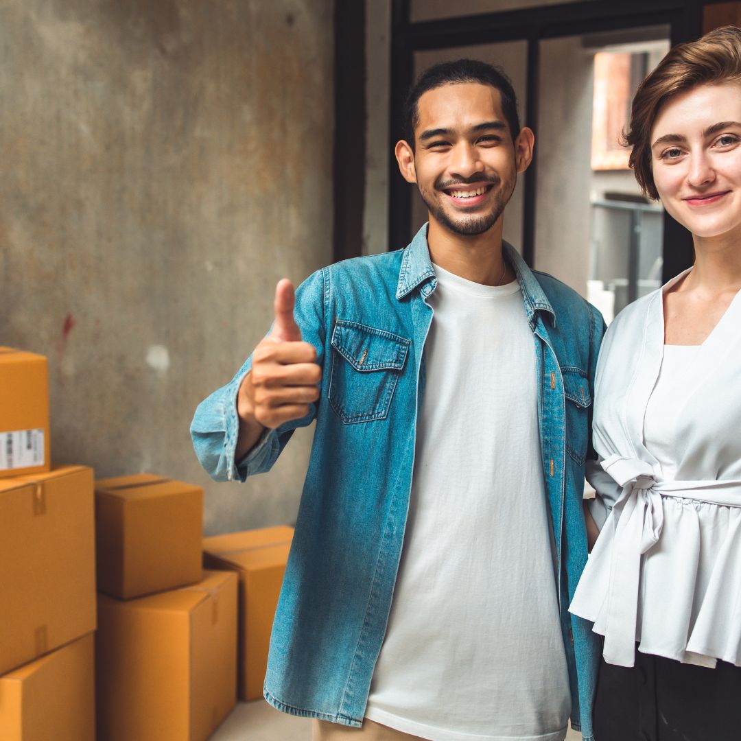 couple outside of home with moving boxes