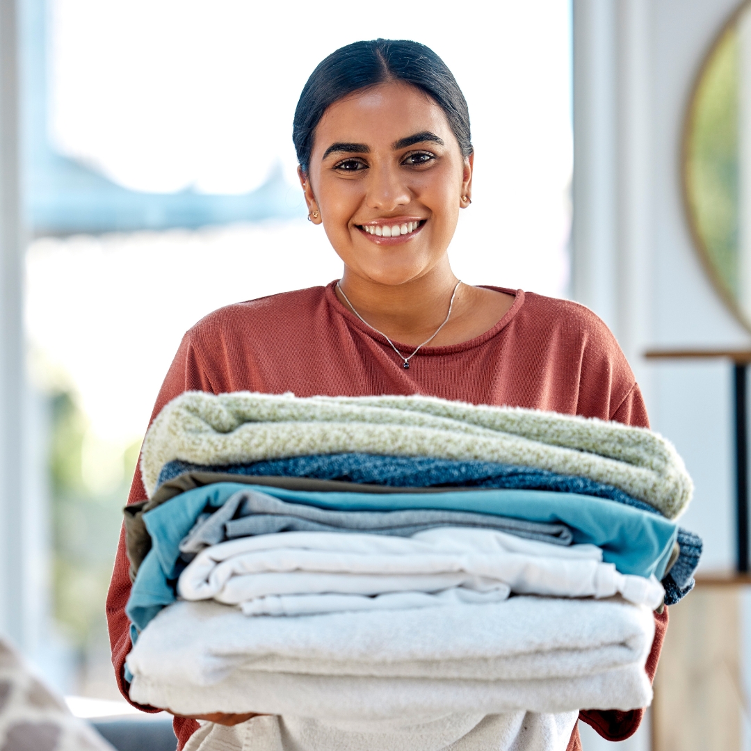 woman with freshly washed sheets and towels