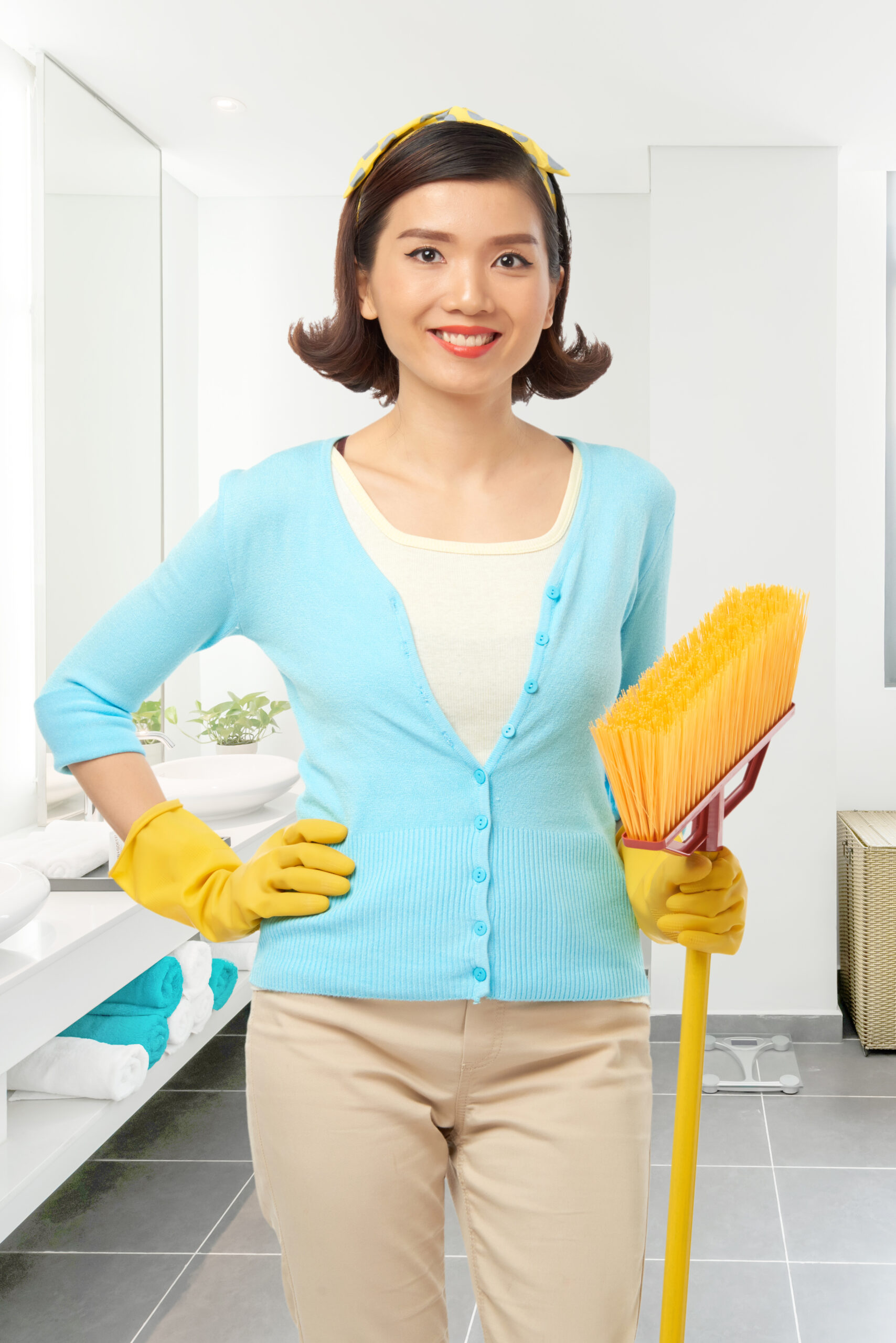 Pretty Vietnamese maid with mop in her hands